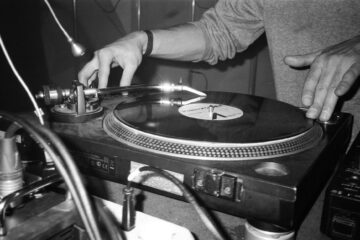 grayscale photography of person playing turntable