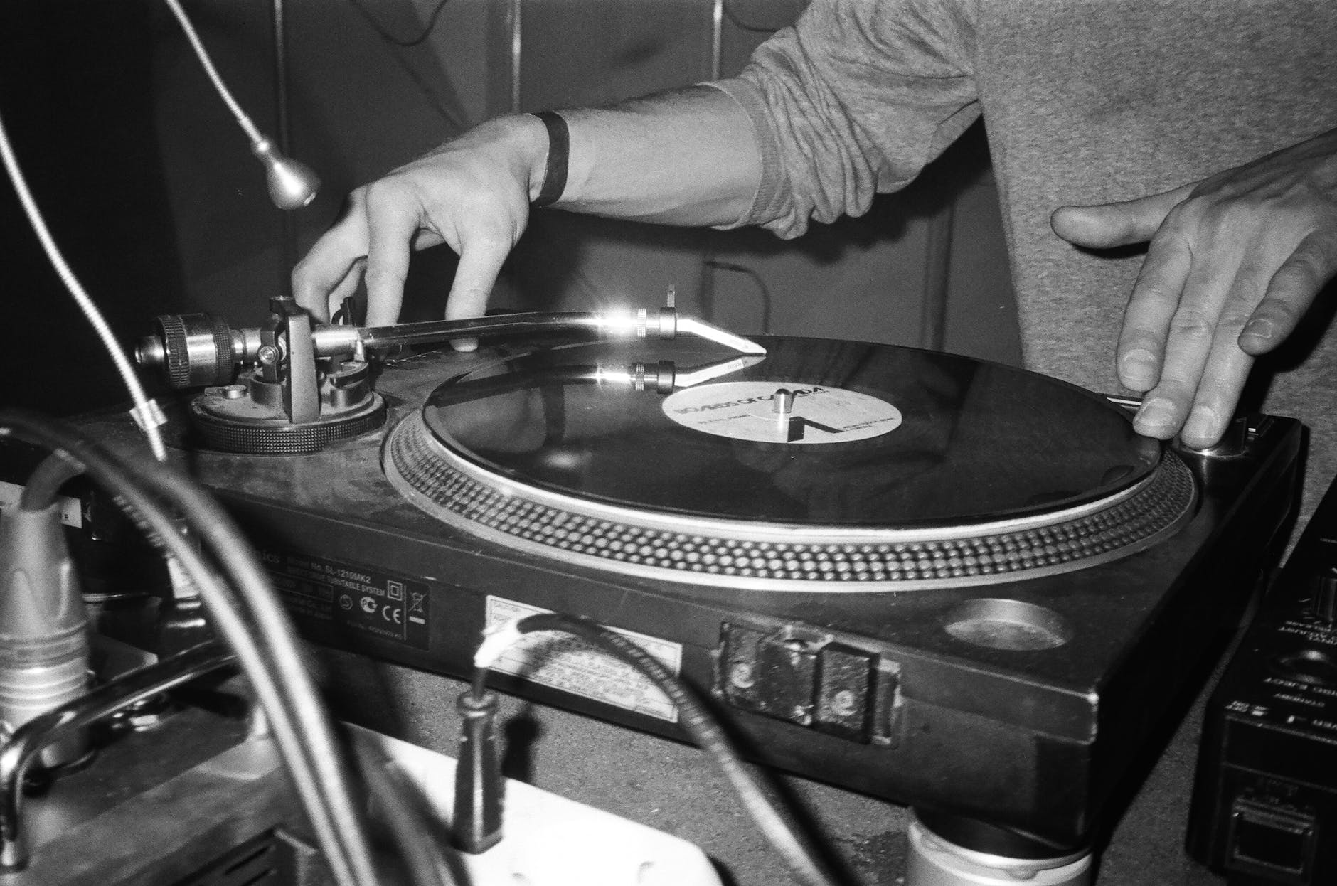 grayscale photography of person playing turntable