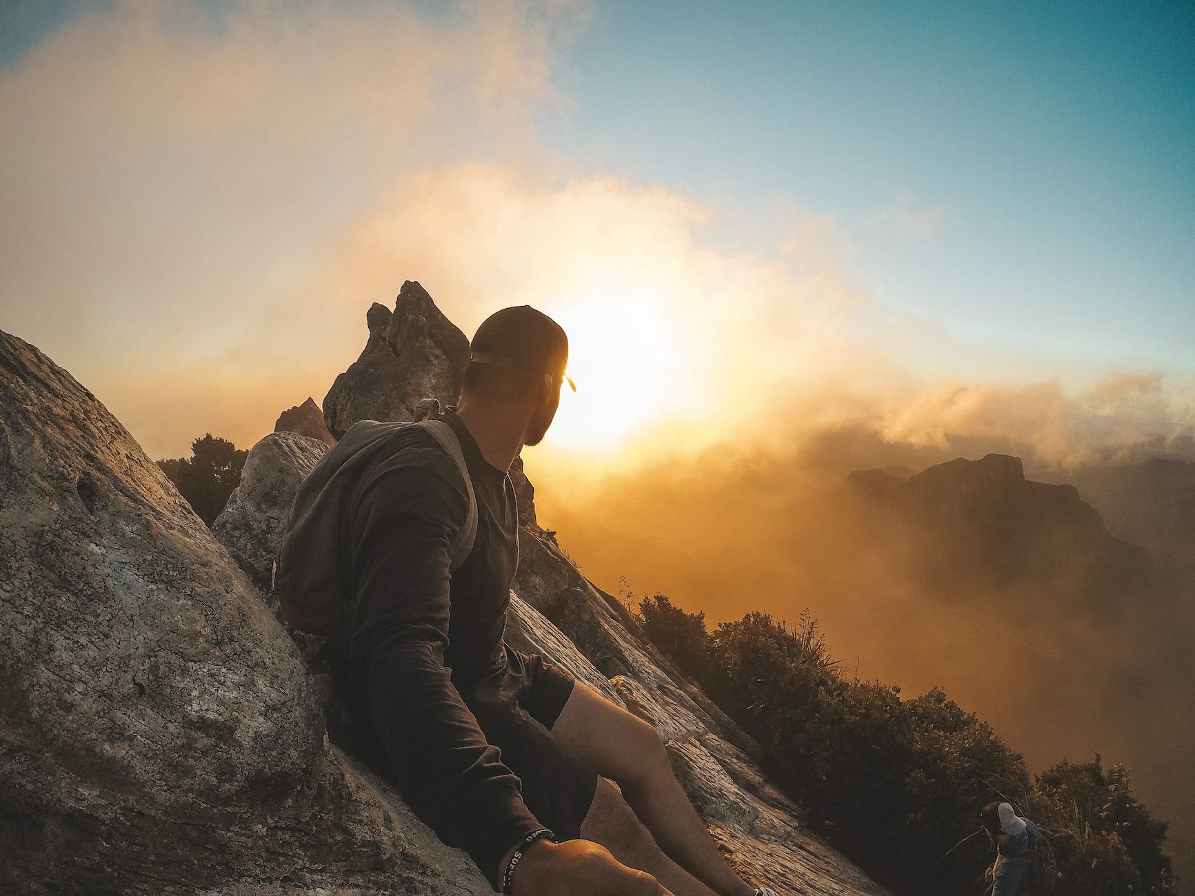 man wearing black long sleeved shirt standing on mountain