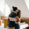 happy couple hugging after moving in new apartment