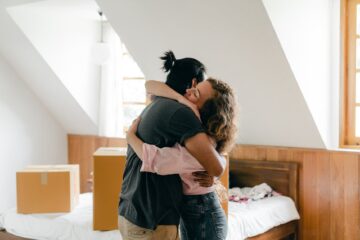 happy couple hugging after moving in new apartment