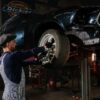 man in blue long sleeve shirt and gray pants standing beside black car