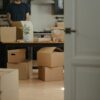 man in black shirt standing near brown cardboard boxes