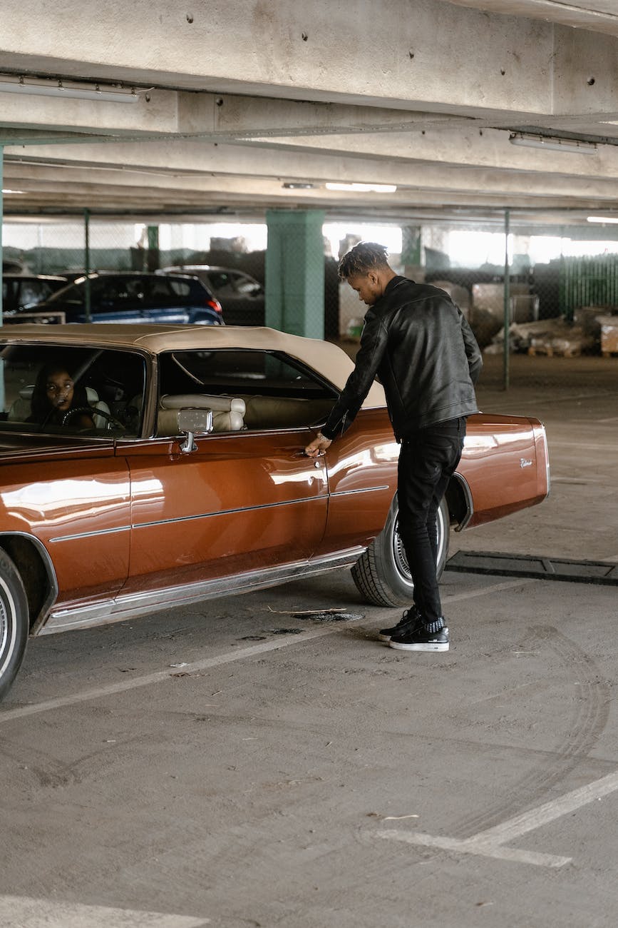 man in black leather jacket getting into the car