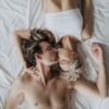 woman and man kissing on bed