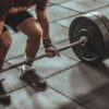 person holding black and silver steel barbell photography